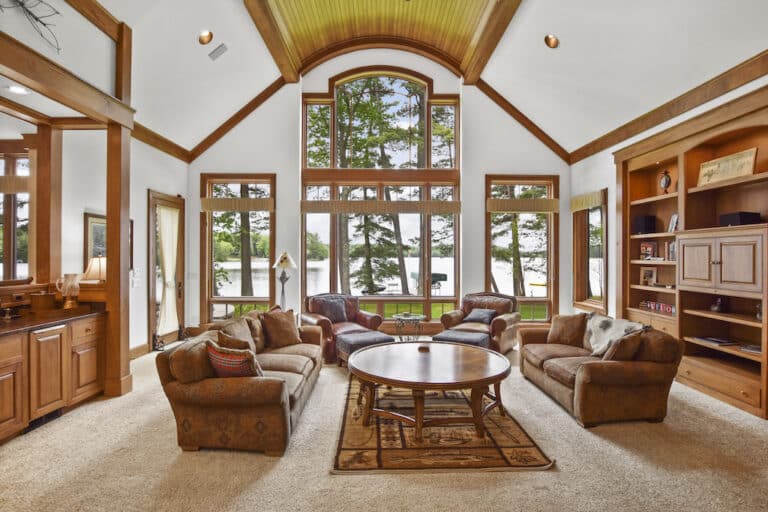 A living room with large windows overlooking a lake.
